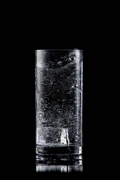 Glass of mineral water with ice on a black background - Photo, Image