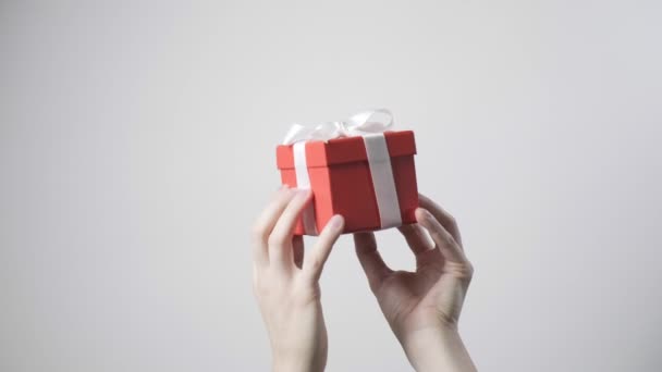 mans mani in possesso di regalo rosso con nastro. natale, anno nuovo, sorpresa di compleanno - Filmati, video