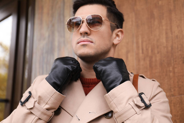 Handsome stylish man wearing black leather gloves outdoors, focus on hands - Fotó, kép