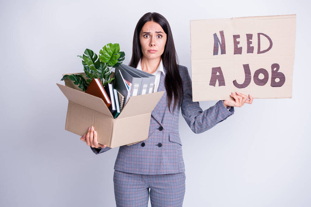Photo of unhappy worker young dismissed lady financial crisis lost work hold carton box stuff fired quit hold placard banner search new opportunity formalwear isolated grey color background - Foto, Imagem