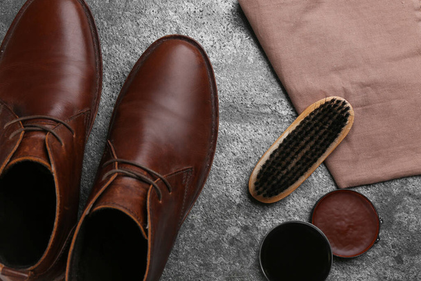 Flat lay composition with shoe care accessories and footwear on grey stone background - Foto, Imagem