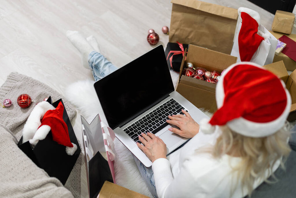 Молода жінка замовляє різдвяні подарунки онлайн - Фото, зображення