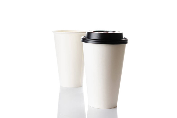 Λευκό χάρτινο κύπελλο για ζεστό καφέ με μαύρο καπάκι που απομονώνεται σε λευκό φόντο. Takeaway κενό μικρό φλιτζάνι τσάι για το σχεδιασμό κειμένου ή πανό σας της μάρκας - Φωτογραφία, εικόνα