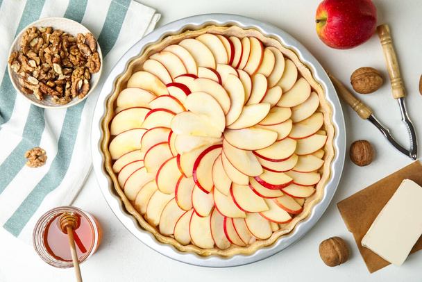 Raw traditional English apple pie in baking dish and ingredients on white table, flat lay - Фото, зображення