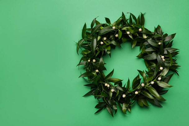 Beautiful handmade mistletoe wreath on green background, top view. Space for text - Foto, Bild