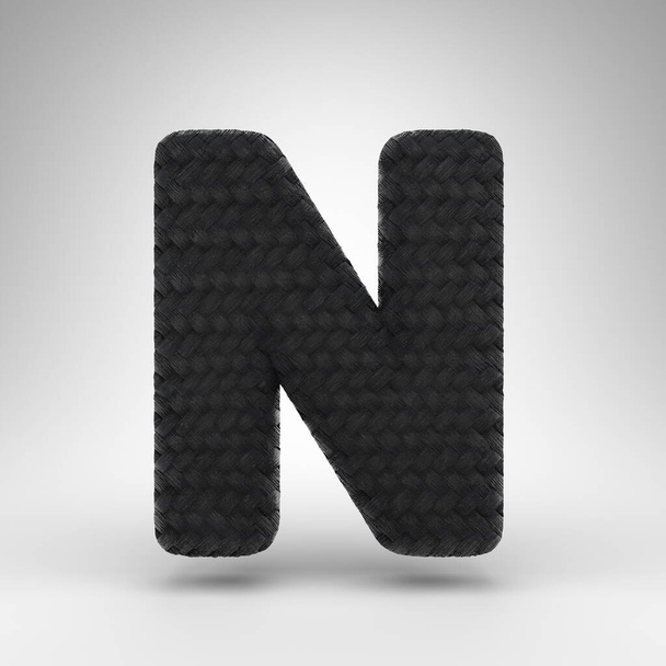 N betű nagybetűvel, fehér háttérrel. Fekete szénszál 3D kiolvasztott betűtípus szénszálas textúrával. - Fotó, kép
