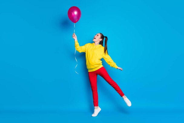 Full length body size view of nice attractive lovely dreamy delighted glad cheerful girl jumping holding in hand air ball having fun enjoying isolated bright vivid shine vibrant blue color background - Foto, immagini