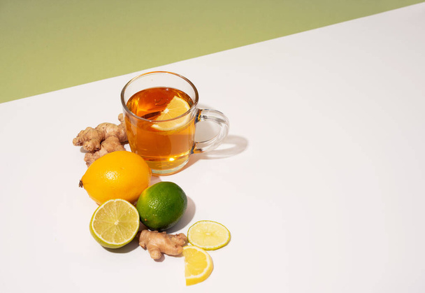 Hot herbal tea with ginger, lemon and honey vitamins C over white and green diagonal isometric projection background. Concept alternative medicine, natural homemade remedy for cold and flu. Support the immune system. Well-Being and Healty - Fotó, kép