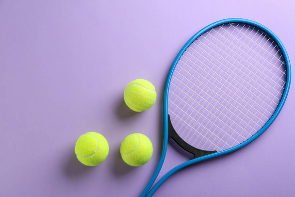 Tennis racket and balls on violet background, flat lay. Sports equipment - Fotoğraf, Görsel