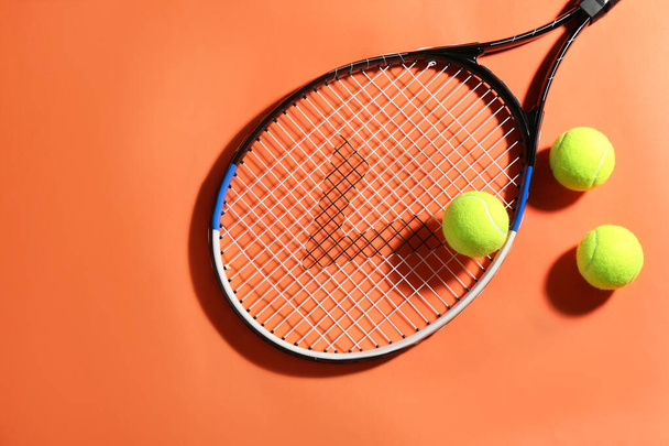 Tennis racket and balls on orange background, flat lay. Sports equipment - Foto, immagini