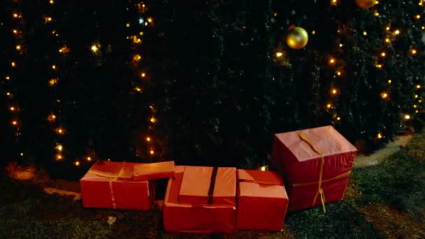 Dárkové krabice u vánočního stromku, v noci ve městě. Koncept Nového roku a vánoční oslavy, - Záběry, video