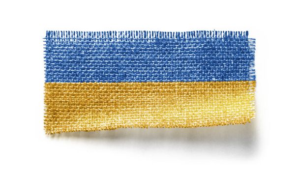 Bandera de Ucrania sobre un trozo de tela sobre un fondo blanco - Foto, Imagen