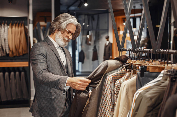 Homem sênior escolhendo um novo terno em uma loja - Foto, Imagem