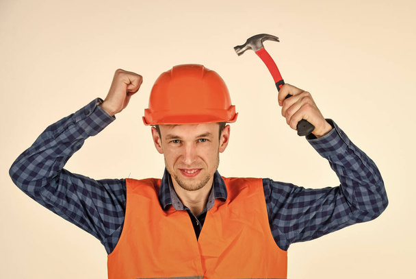 building tool repair equipment. young worker is engineer assistant. repairman in uniform. man work with hammer. real construction worker in helmet. carpenter ready to work - Фото, зображення