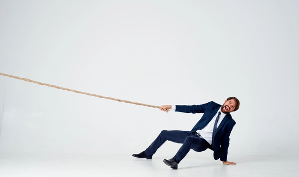 Mann mit Seil in der Hand auf leichtem Hintergrund Business Finance  - Foto, Bild