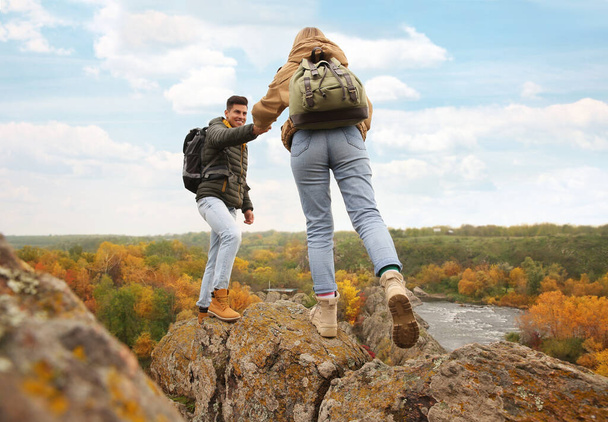 Couple of hikers with backpacks climbing up mountains - Foto, Imagem