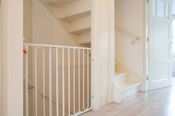 Chroniące białe dziecko bezpieczne schody bramy w korytarzu klatki schodowej nowoczesny nowy dom, ogrodzenie dla dzieci w pięknym domu - Zdjęcie, obraz