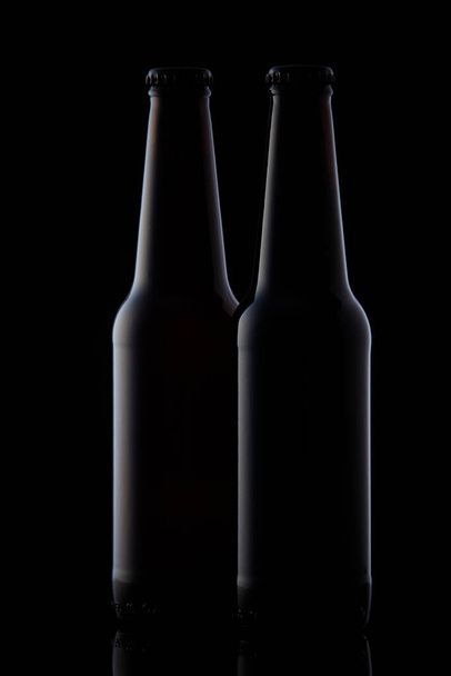 Two black bottles on black background - Φωτογραφία, εικόνα