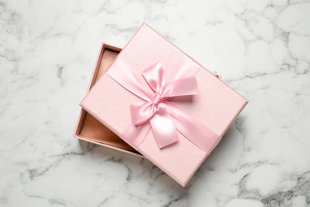 Beautiful pink gift box on white marble table, top view - Foto, imagen