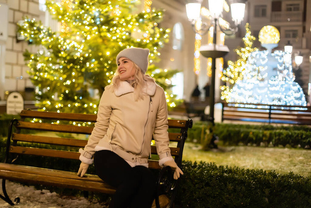 クリスマスマーケットを歩いている女の子は、夕方には休日の光で飾られています。大都市で幸せな気分。赤の広場,モスクワ,ロシアに冬の休暇を過ごす. - 写真・画像