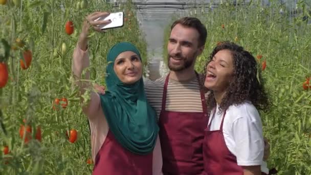 Ευτυχισμένο και ποικίλο θερμοκήπιο εργαζόμενοι χαμογελώντας για selfie - Πλάνα, βίντεο