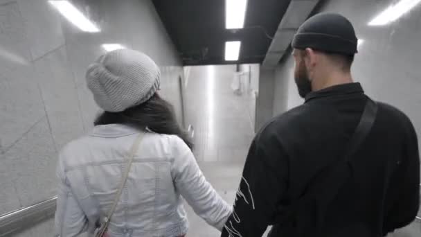 Mladý mezirasový pár sestupující po schodech do metra. Afro-americká dívka a běloch pomocí veřejné dopravy.  - Záběry, video