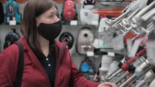 Mädchen in medizinischer Maske kauft Lebensmittelmixer im Geschäft - Filmmaterial, Video
