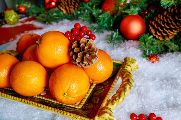 Pomarańcze sezonowe na tacy świątecznej z ozdobą. Nowy Rok lub koncepcja Bożego Narodzenia. - Zdjęcie, obraz