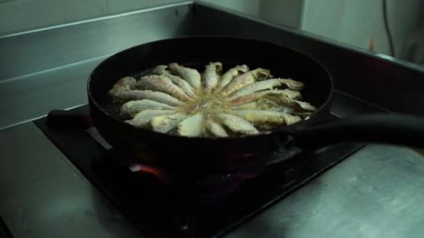 Gezicht op het bakken van capelin vis in ijzeren pan - Video