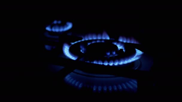 Schalten Sie in der Nacht in der Küche Gasbrenner ein, die mit einer blauen Flamme lodern. Nahaufnahme - Filmmaterial, Video