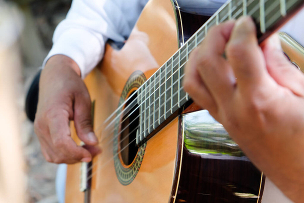 Κοντινή εικόνα του ανθρώπου να παίζει ακουστική κιθάρα  - Φωτογραφία, εικόνα
