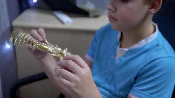 Trauriger Junge hält goldenen Weihnachtsstern in Händen und dreht ihn - Filmmaterial, Video