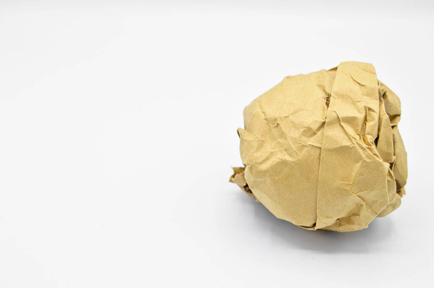 Crumpled beige cardboard paper ball in office, isolated on white background - Photo, Image