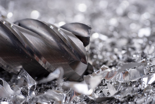 Cortador de molino de plata con virutas de metal. Procesamiento de metales ferrosos en una fábrica - Foto, Imagen