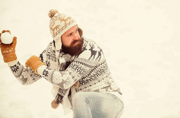 Making snowball. Happiness concept. Smiling man snow background. Snow games. Have fun winter day. Cheerful bearded hipster knitted hat and warm gloves play with snow outdoors. Christmas holidays - Zdjęcie, obraz