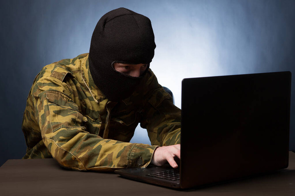 Masked cyber terrorist in military uniform hacking army intelligence - Photo, image
