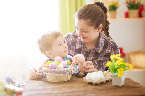 A mother and her son painting Easter eggs. Happy family preparing for Easter holiday. Happy easter. - Фото, изображение