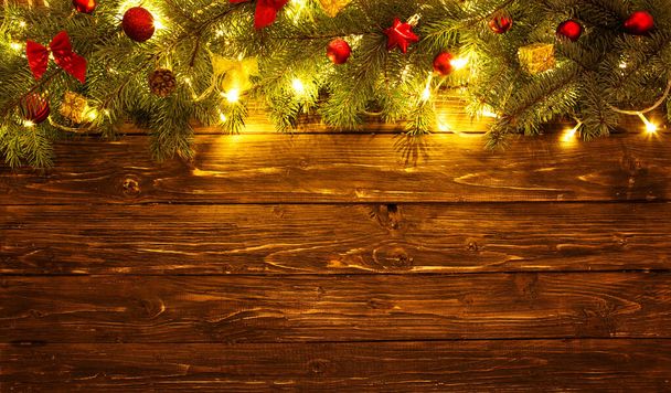 Christmas decoration and christmas lights frame on wooden background. - Фото, изображение