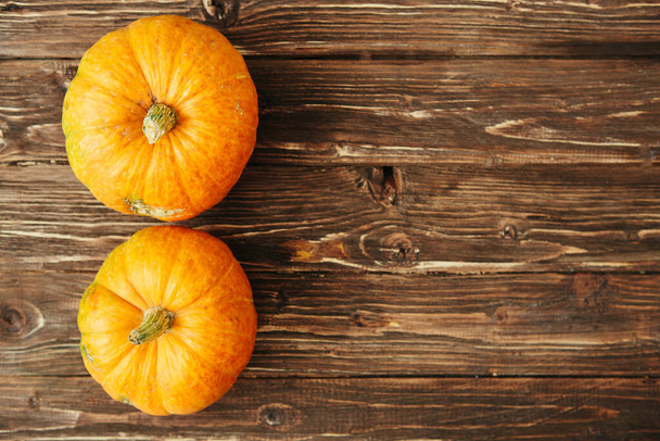 Orange pumpkins on brown wooden table, country autumn background. Organic food and healthy food concept Thanksgiving and Halloween concept. View from above. Top view. Copy space for text and design - 写真・画像