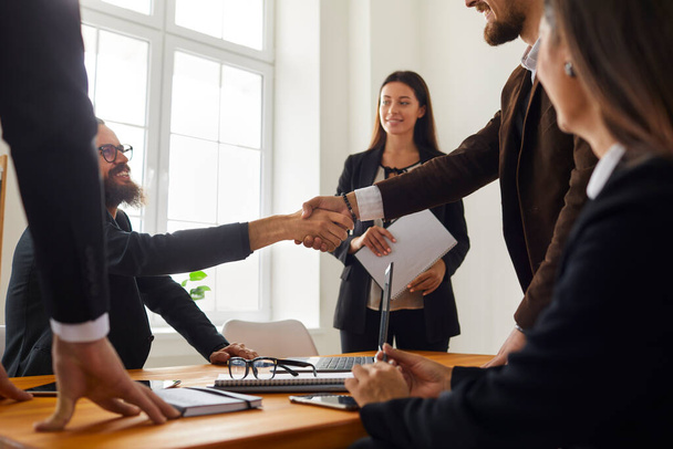 Business people making a deal and shaking hands after a negotiation meeting in the office - Photo, Image