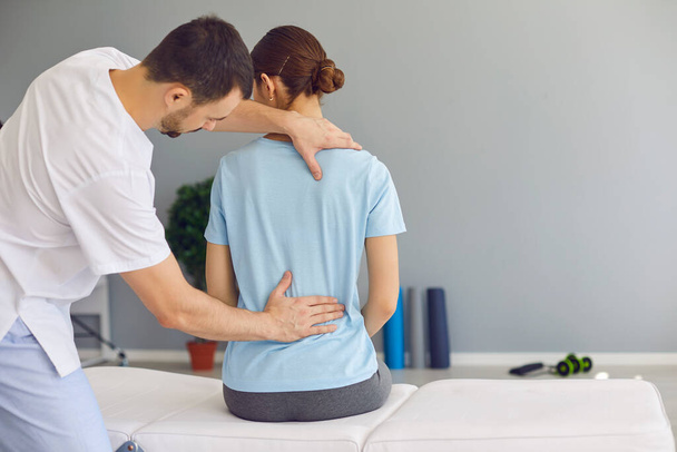 Professioneller Osteopath fixiert weibliche Rückenmuskeln während der Rehabilitation - Foto, Bild