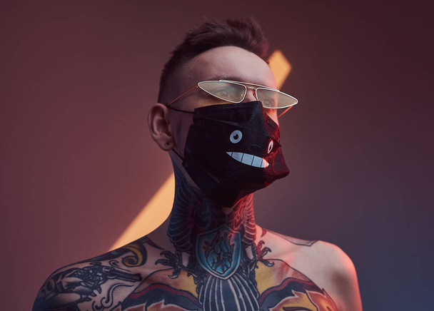 Hister caucasiano com máscara protetora e óculos de sol em estúdio - Foto, Imagem
