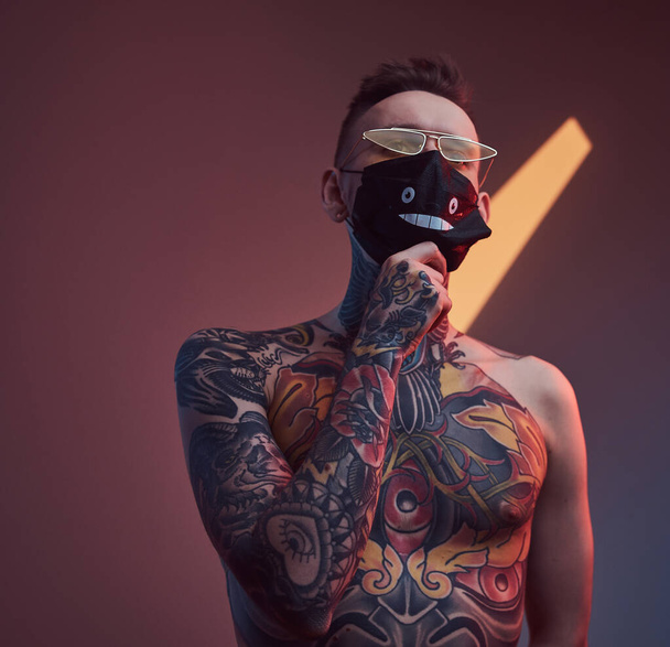 Fashionable and topless guy weared with protective mask in studio - Photo, Image