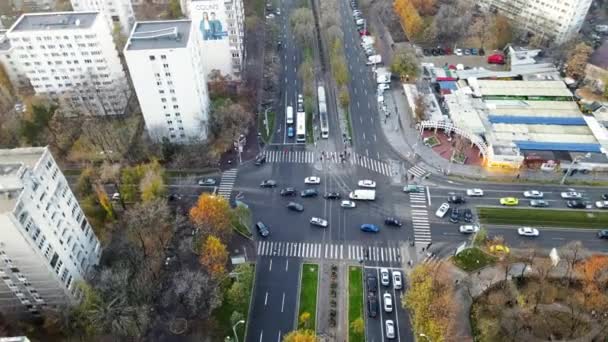 BUCHAREST, ROMANIA - 2020年12月9日:移動する車、通りを横断する人々、トラム、裸の木や住宅の建物、ドローンからの眺め、パノラマ - 映像、動画
