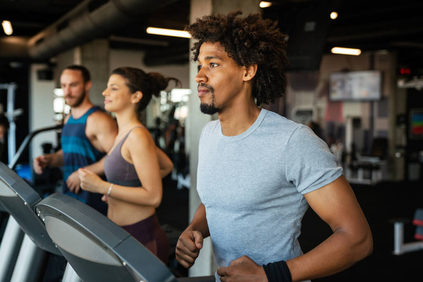 Group of young fit people running on treadmills in modern sport gym - Φωτογραφία, εικόνα