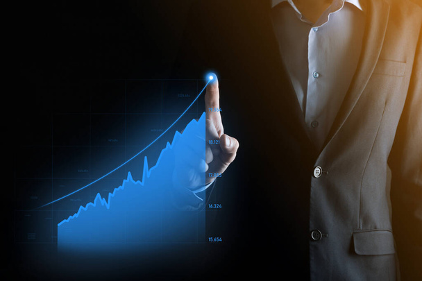 Бізнесмен тримає планшет і показує голографічні графіки і статистика фондового ринку отримує прибуток. Концепція планування зростання та бізнес-стратегії. Відображення цифрового екрану доброї економіки
 - Фото, зображення
