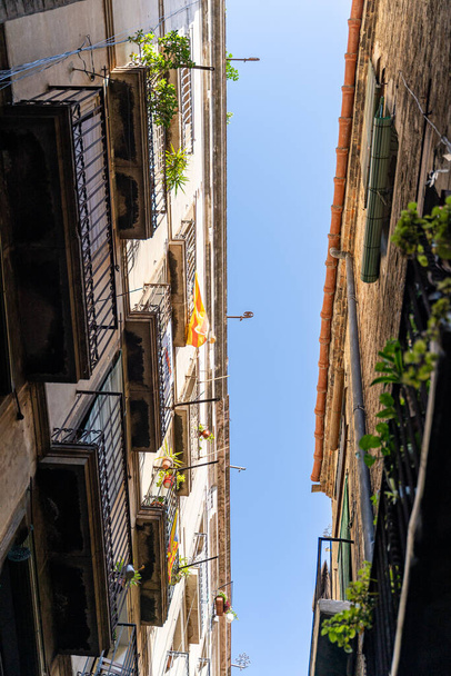 Narrow street with old historic houses with windows, balconies in Barcelona - Фото, зображення