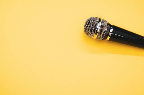 Uma visão superior de um microfone em uma superfície amarela - Foto, Imagem