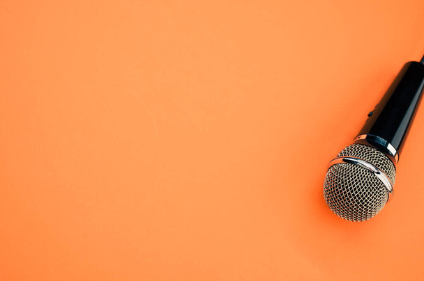 Вид сверху на микрофон на оранжевой поверхности - Фото, изображение
