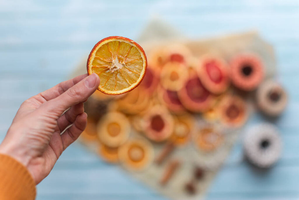 kuivattuja appelsiineja kädessä diy hankkeita ja nolla jätettä joulukoristeita - Valokuva, kuva